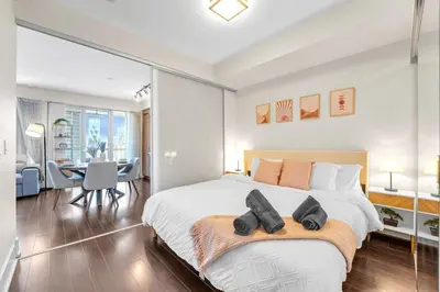 a bedroom with a large bed and a dining room at Boho 2bdrm Sleeps 6 near Rogers MTCC Union CN tower in Toronto