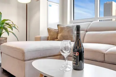a bottle of wine and a glass on a table in a living room at Boho 2bdrm Sleeps 6 near Rogers MTCC Union CN tower in Toronto