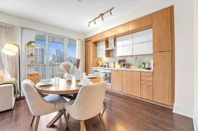a kitchen and dining room with a table and chairs at Boho 2bdrm Sleeps 6 near Rogers MTCC Union CN tower in Toronto