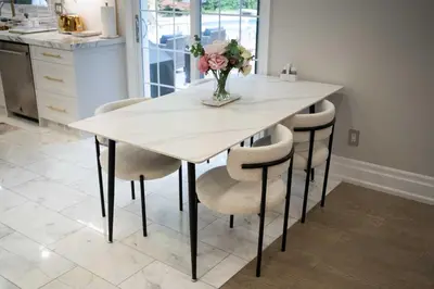 a dining room table with chairs and a vase of flowers at 6 Bedroom Luxury House with a Bright Sunroom in Mississauga