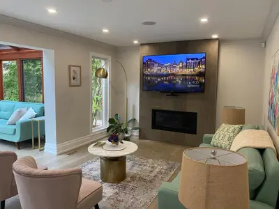 a living room with a tv on a wall at 6 Bedroom Luxury House with a Bright Sunroom in Mississauga