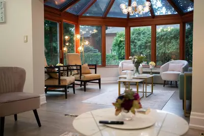 a living room with a conservatory with chairs and tables at 6 Bedroom Luxury House with a Bright Sunroom in Mississauga