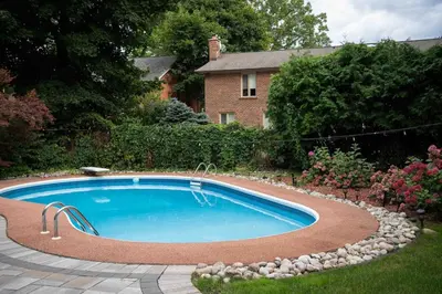 a swimming pool with rocks around it in a yard at 6 Bedroom Luxury House with a Bright Sunroom in Mississauga