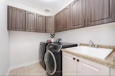 a kitchen with a washing machine and a sink at Beautiful 4 bed, 3 master bedrooms-pvt washrooms in Brampton