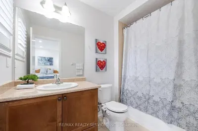 a bathroom with a toilet and a sink and a mirror at Beautiful 4 bed, 3 master bedrooms-pvt washrooms in Brampton