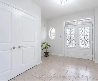 a white room with a door and a potted plant at Beautiful 4 bed, 3 master bedrooms-pvt washrooms in Brampton