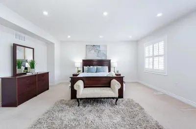 a bedroom with a bed and a dresser and a mirror at Beautiful 4 bed, 3 master bedrooms-pvt washrooms in Brampton
