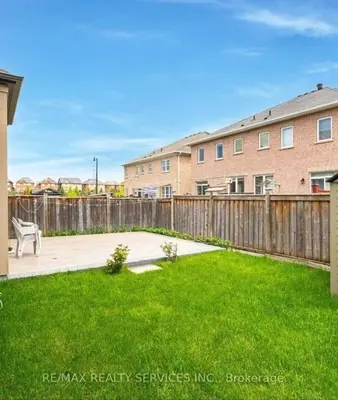 a yard with a wooden fence and a bench at Beautiful 4 bed, 3 master bedrooms-pvt washrooms in Brampton