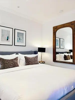 a bedroom with a large bed with a mirror at Hazelton Heritage in Toronto