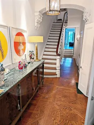 a hallway with a staircase and a table with a lamp at Hazelton Heritage in Toronto