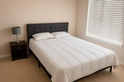 a bedroom with a bed with a black headboard and a window at 2 Bedroom Condo in Milton in Milton
