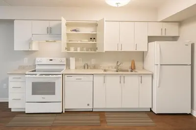 a kitchen with white cabinets and a white refrigerator at 2 Bedroom Condo in Milton in Milton