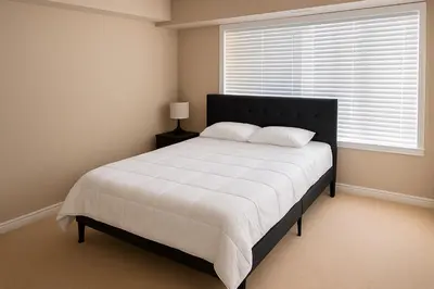 a bedroom with a large bed with a large window at 2 Bedroom Condo in Milton in Milton