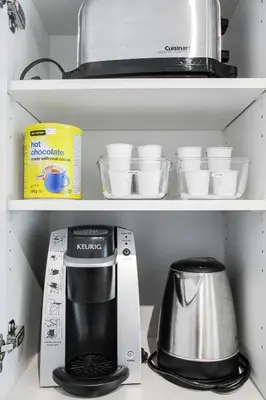 a kitchen shelf with a coffee maker and cups at Panorama Luxe Suites - Prime Downtown Location in Toronto