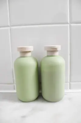 two green bottles sitting on a counter in a bathroom at Panorama Luxe Suites - Prime Downtown Location in Toronto