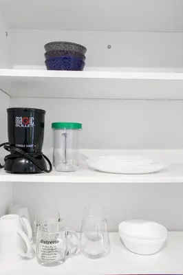 a shelf with a coffee maker and dishes on it at Panorama Luxe Suites - Prime Downtown Location in Toronto