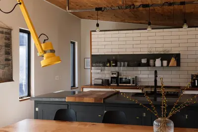 a kitchen with black cabinets and a counter top at Willow Creek - Modern Sunlit Bungalow in Hillier