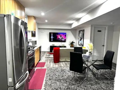 a kitchen and living room with a refrigerator and a table at Gateway to Serenity-Welcome home in London
