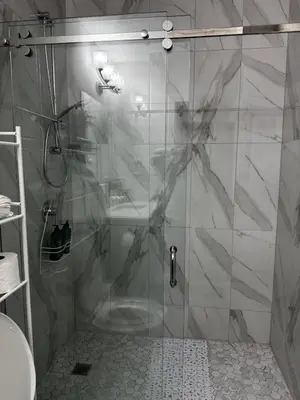 a shower with a glass door in a bathroom at Gateway to Serenity-Welcome home in London