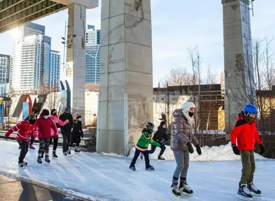 a group of people playing in the snow under a bridge at Luxury CN Tower Suites - Save on Monthly Stays in Toronto