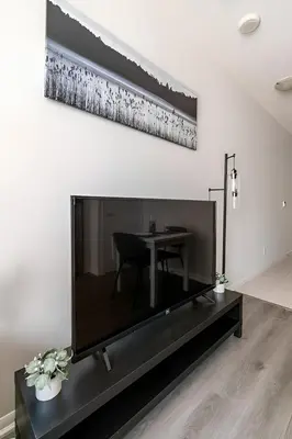 a living room with a large television and a table at Luxury CN Tower Suites - Save on Monthly Stays in Toronto