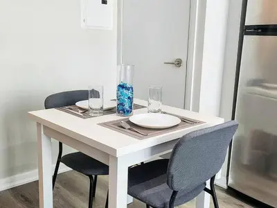 a white table with two chairs and a plate and glasses at Luxury CN Tower Suites - Save on Monthly Stays in Toronto