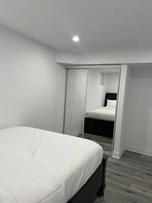 a white bedroom with a bed and a mirror at Welcome to Skies Abode in Paris