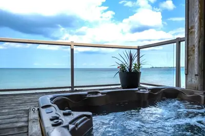 a hot tub with a view of the ocean at Blue View Chalets in Blue Mountains