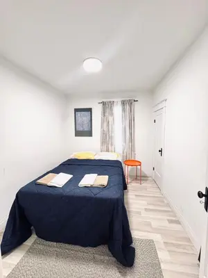a bedroom with a bed with a blue blanket at Bright 2bedroom apartment in Hamilton