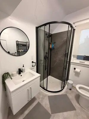 a bathroom with a shower and a sink and a mirror at Bright 2bedroom apartment in Hamilton