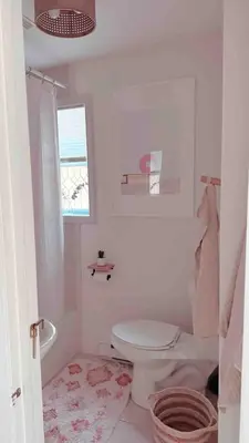 a white bathroom with a toilet and a window at Cozy Coach House in Kitchener