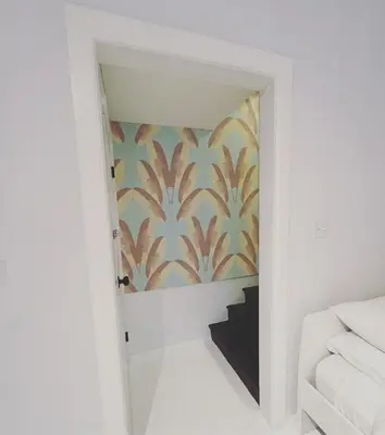 a hallway with a stairwell with a patterned wall at Cozy Coach House in Kitchener