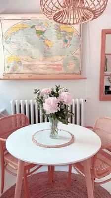 a white table with a vase of pink flowers on it at Cozy Coach House in Kitchener