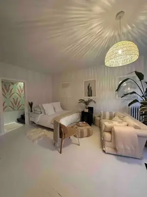 a living room with two beds and a chandelier at Cozy Coach House in Kitchener