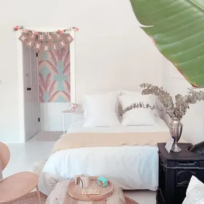 a white bedroom with a bed and a table at Cozy Coach House in Kitchener