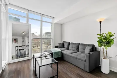 a living room with a couch and a large window at Apartment in Downtown Toronto in Toronto