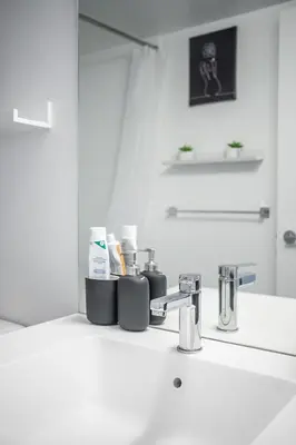 a bathroom sink with two cups and a mirror at Apartment in Downtown Toronto in Toronto