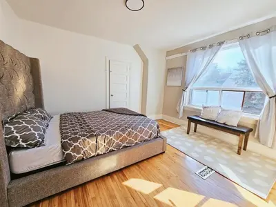 a bedroom with a bed and a large window at Downtown Toronto Apartments in Toronto