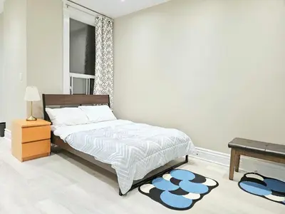 a bedroom with a bed and a desk and rug at Downtown Toronto Apartments in Toronto