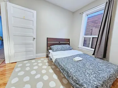 a bedroom with a bed and a window at Downtown Toronto Apartments in Toronto