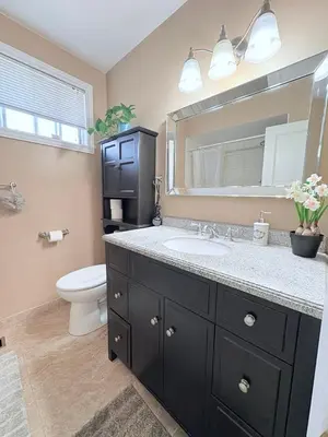 a bathroom with a sink and a toilet and a mirror at Cozy Stay, Self Check-In with Parking available upon request in Toronto