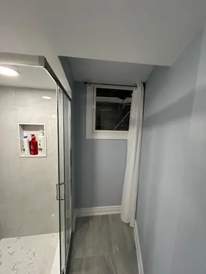 a bathroom with a walk in shower and a window at Beautiful and cozy unit in Mississauga