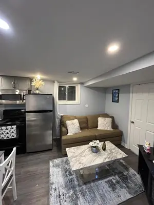 a living room with a couch and a kitchen at Beautiful and cozy unit in Mississauga