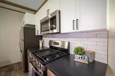 a kitchen with a black counter top with a stove at Scugog Landing Resort in Port Perry