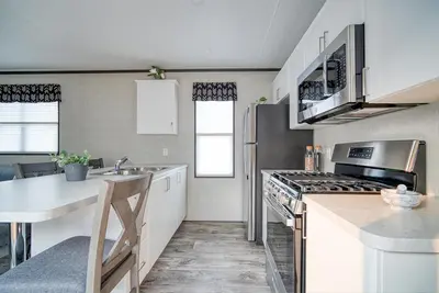a kitchen with a sink and a stove top oven at Scugog Landing Resort in Port Perry