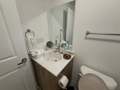 a bathroom with a sink and a toilet and a mirror at Brand New 2 Storey Unit With A Free Parking Space in Richmond Hill