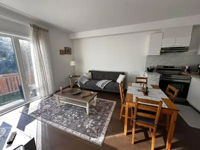 a living room with a table and a couch at Brand New 2 Storey Unit With A Free Parking Space in Richmond Hill