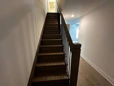 a wooden staircase in a room with a wall at Brand New 2 Storey Unit With A Free Parking Space in Richmond Hill