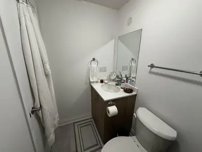 a bathroom with a toilet and a sink and a mirror at Brand New 2 Storey Unit With A Free Parking Space in Richmond Hill