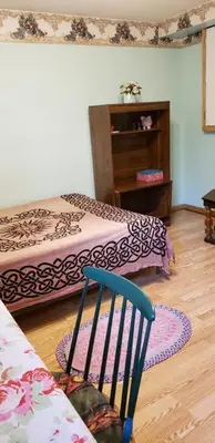 a room with two beds and a blue chair at 2 bdrm apartment 3 min walk to McMaster University in Hamilton